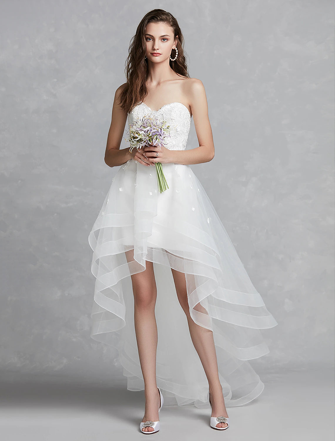 Chic A-Line sweetheart strapless white reception bridal gown with lace appliques and asymmetrical hem.