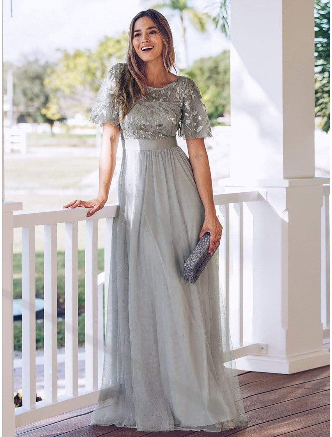 Model wearing an elegant A-Line Empire prom dress with short sleeves.