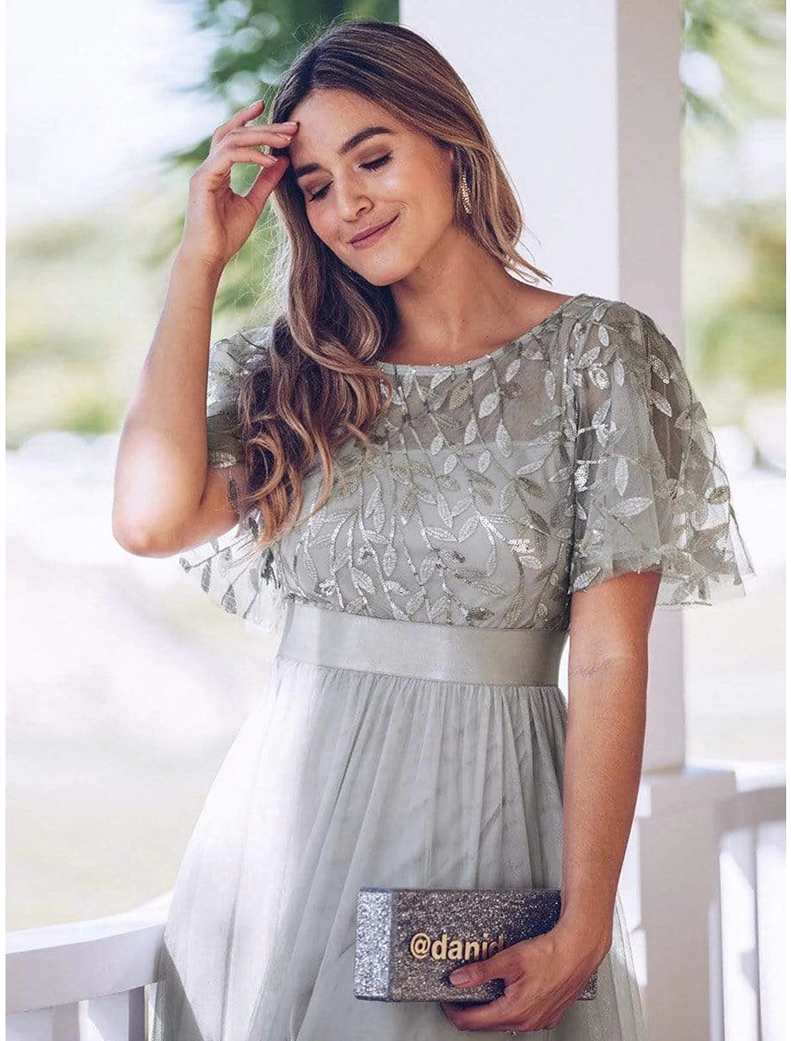 Close-up of the jewel neck and embroidered short illusion sleeves on the dress.