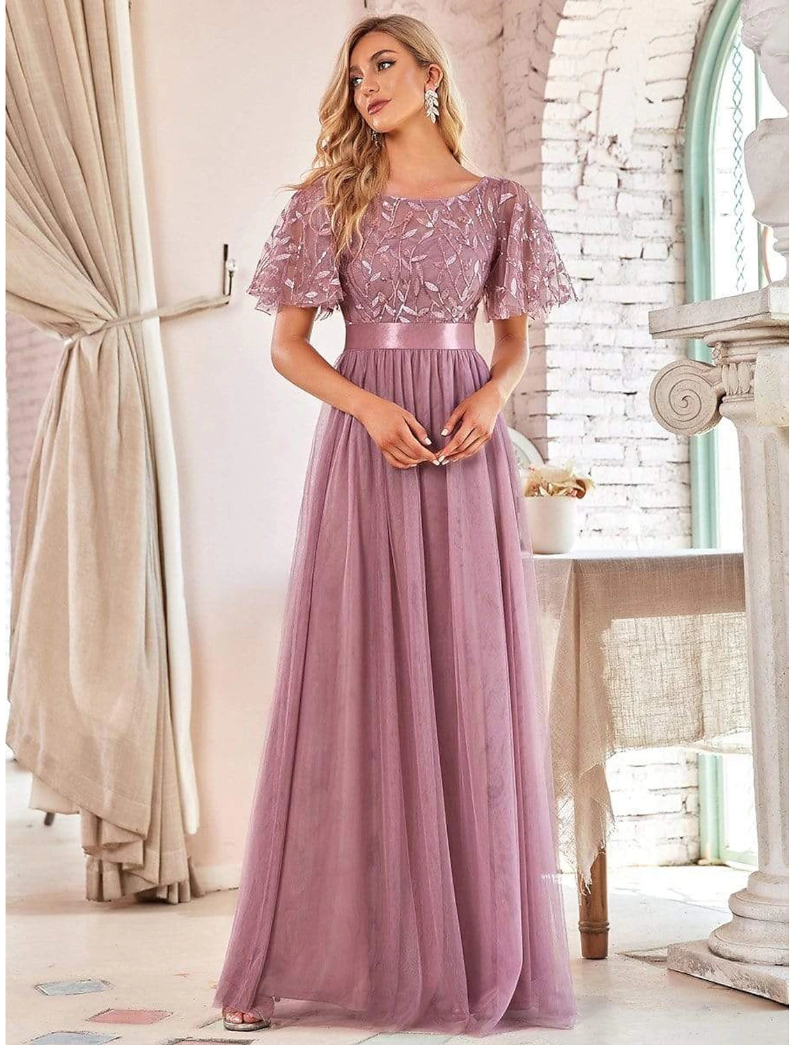 Model showcasing the flowing floor-length tulle skirt of the dress.