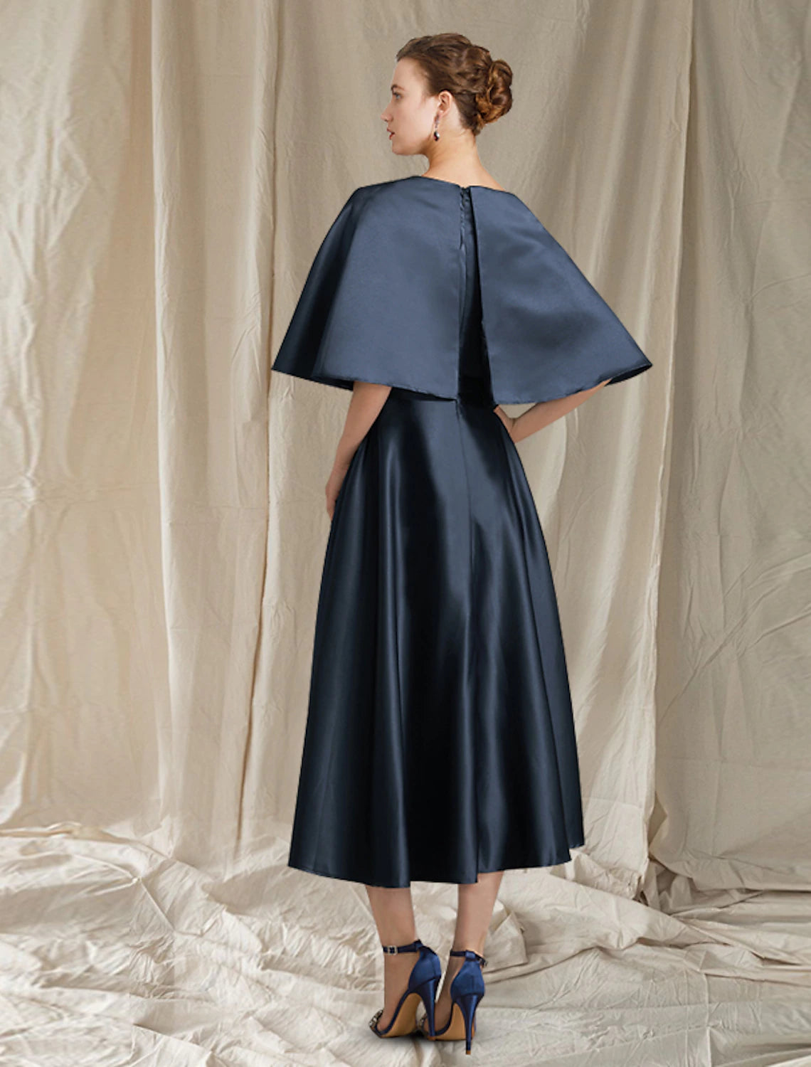 Woman wearing an elegant A-Line pleated satin dress with half sleeves.