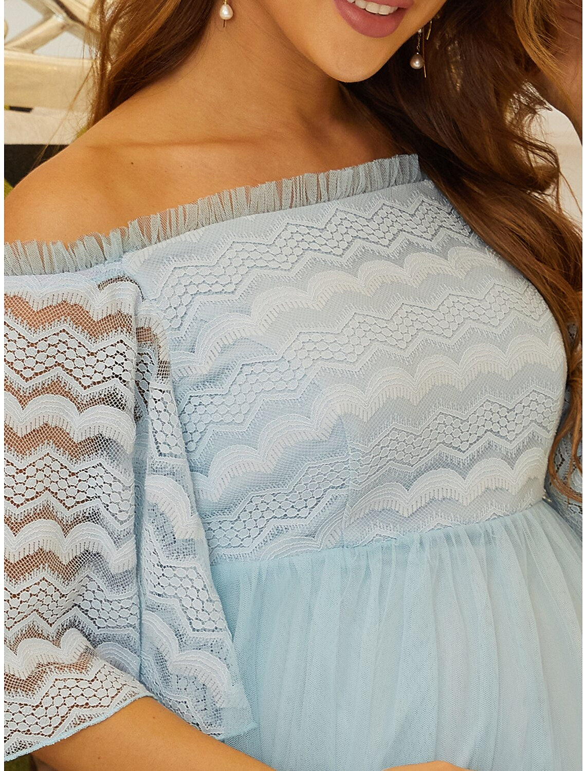 Close-up of the off-shoulder neckline and lace tulle bodice of the elegant dress.