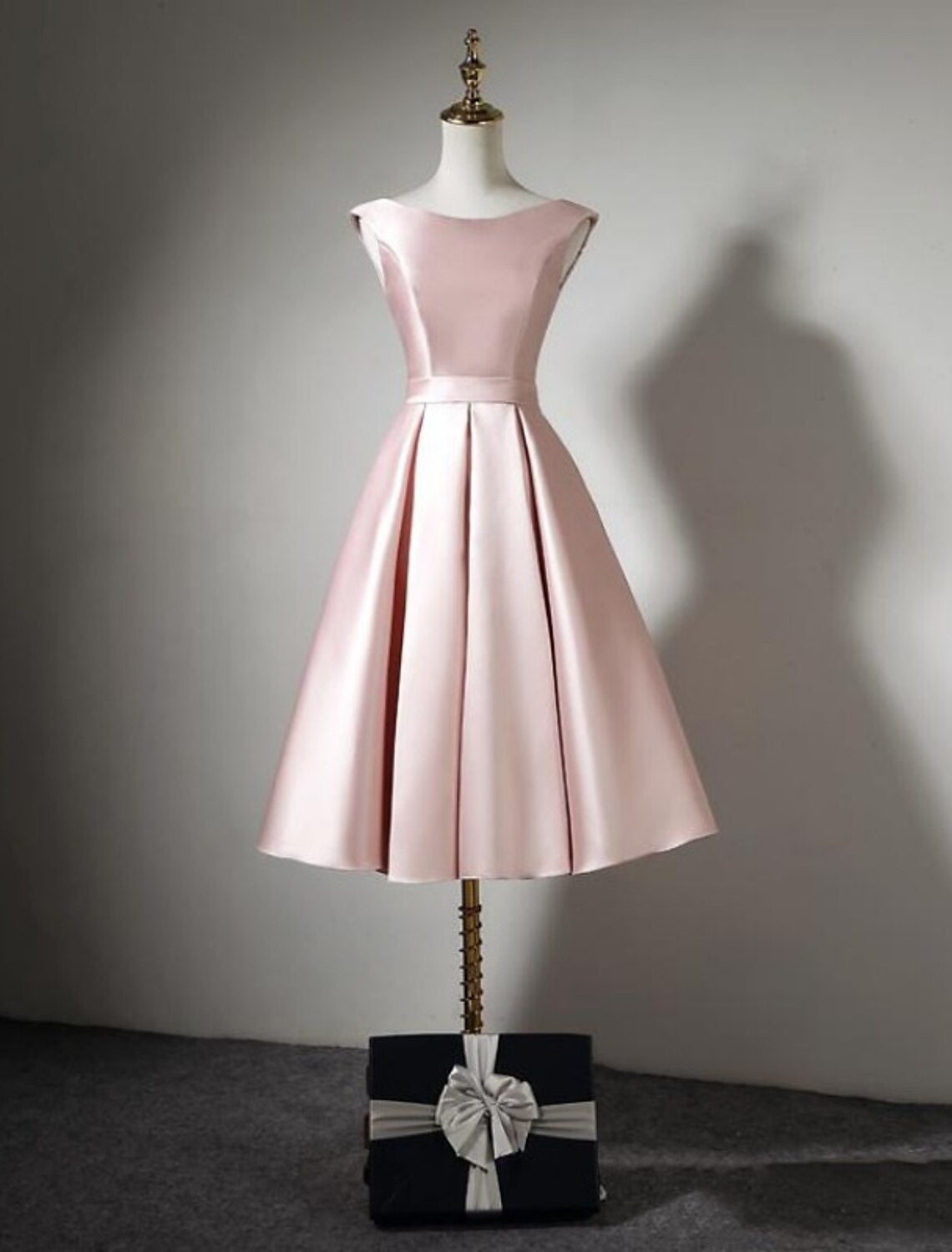 Side view of an A-line off-shoulder satin tea-length bridesmaid dress.