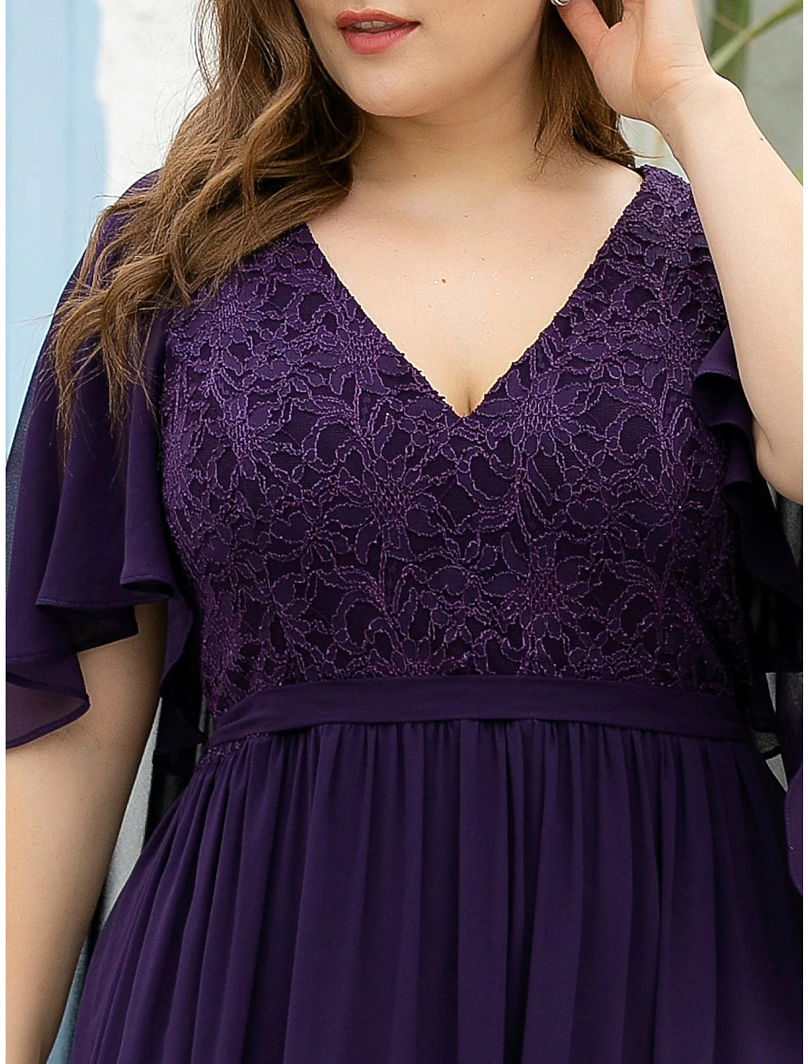 Close-up of the V-neckline and half sleeves on an elegant chiffon plus size Mother of the Bride dress.