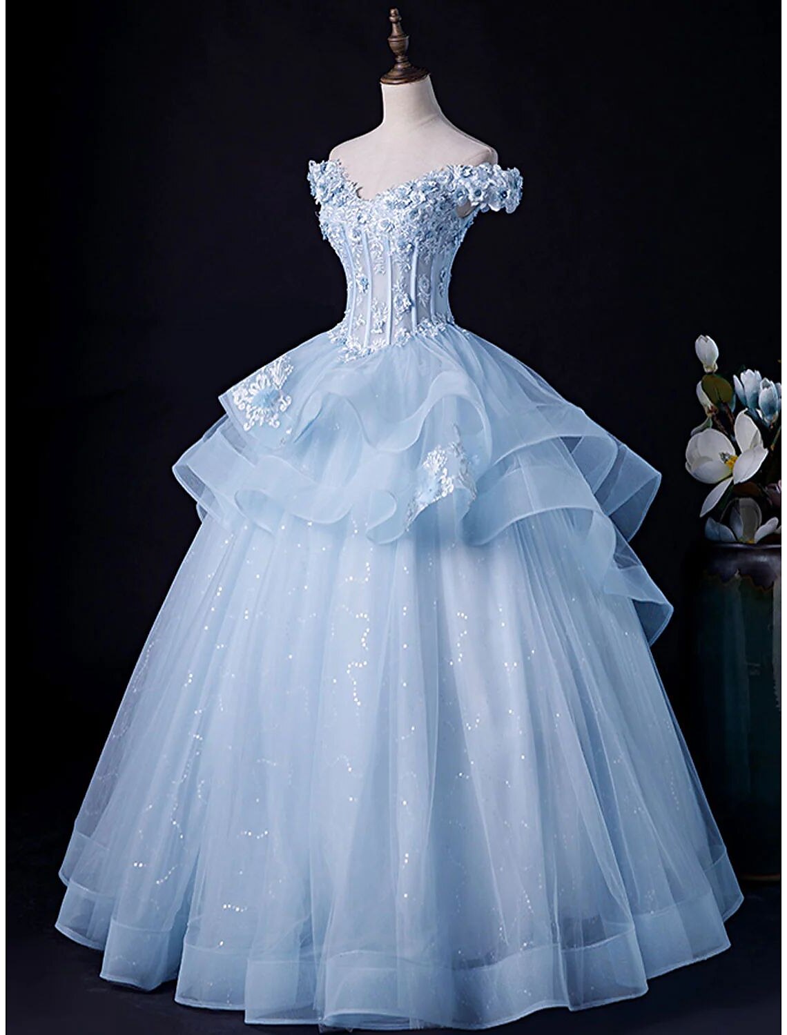 Close-up of the off-shoulder neckline and delicate appliques on the formal evening dress.