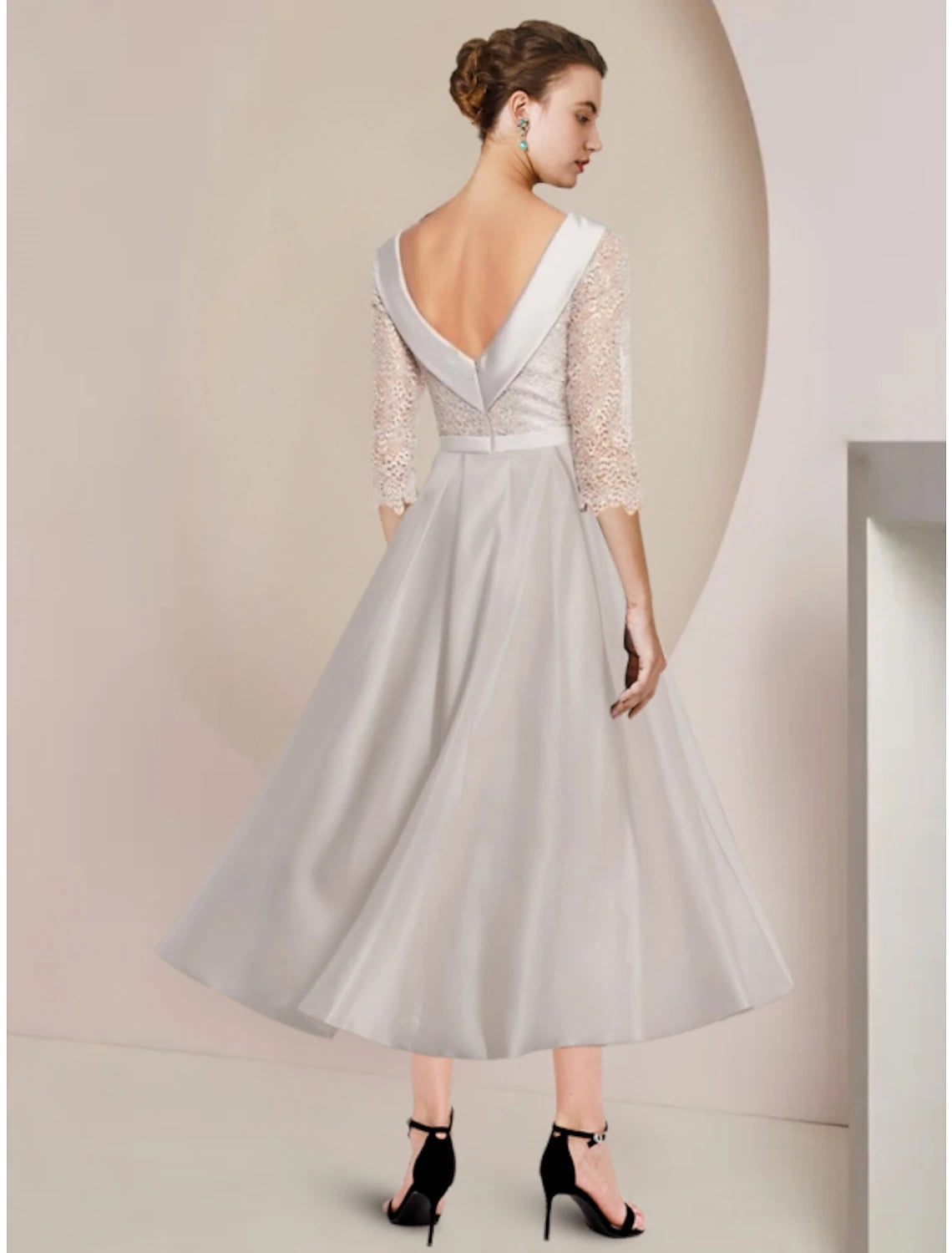 Side view of an elegant sheath dress, highlighting the tea-length and ruched half sleeve.