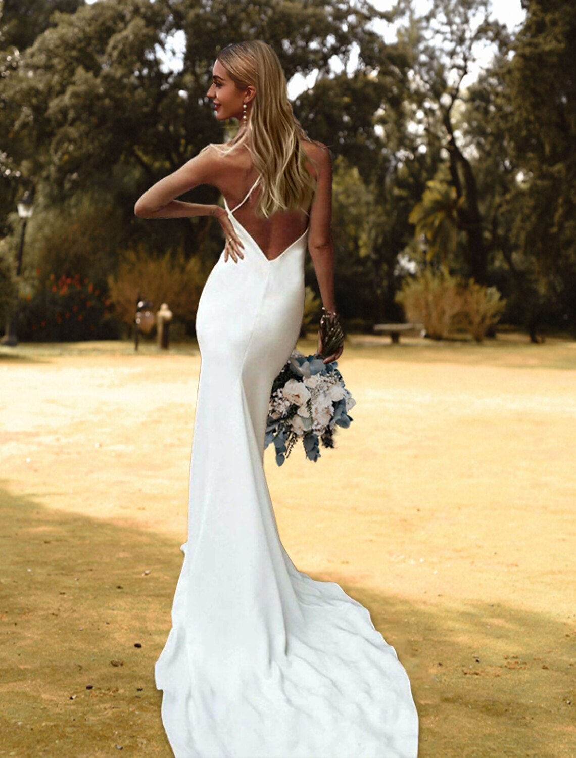 Back view of an elegant white charmeuse sheath wedding dress with spaghetti straps and court train.