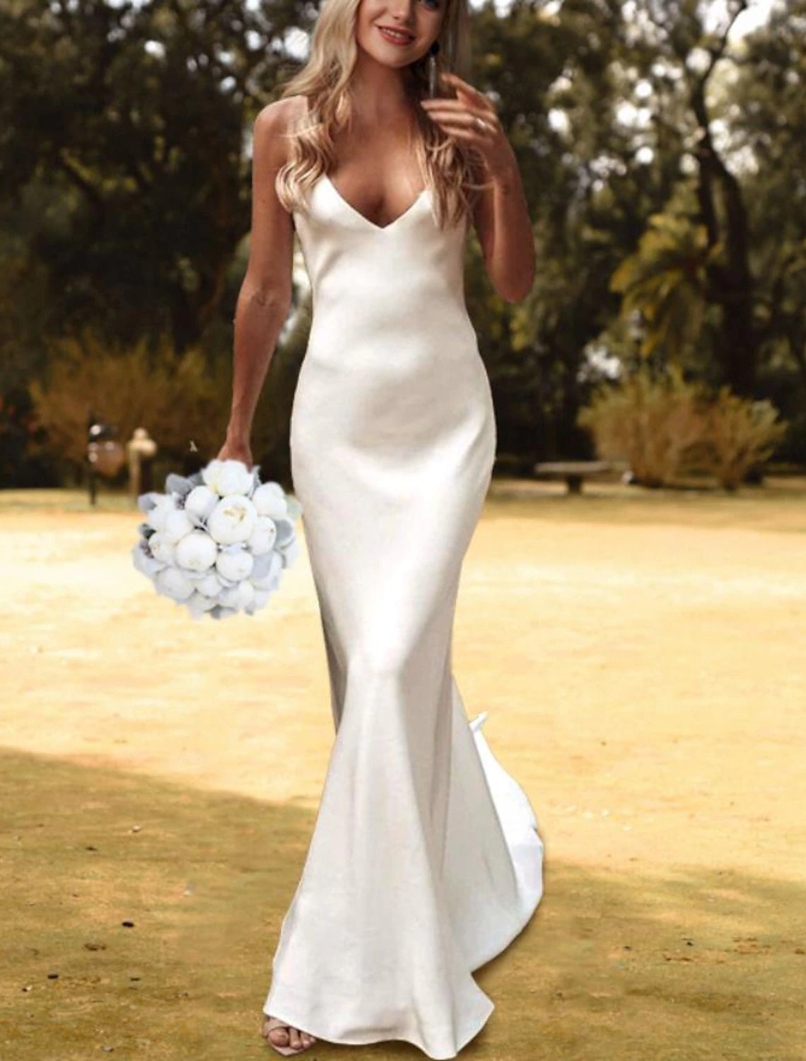 Side view of a white V-neck charmeuse bridal gown with spaghetti straps and a flowing court train.