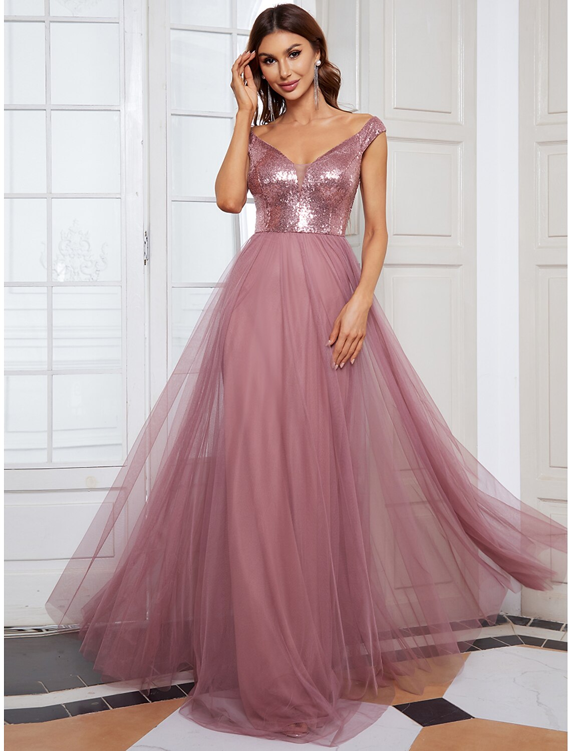 Woman wearing an elegant V-neck sleeveless floor-length bridesmaid dress.