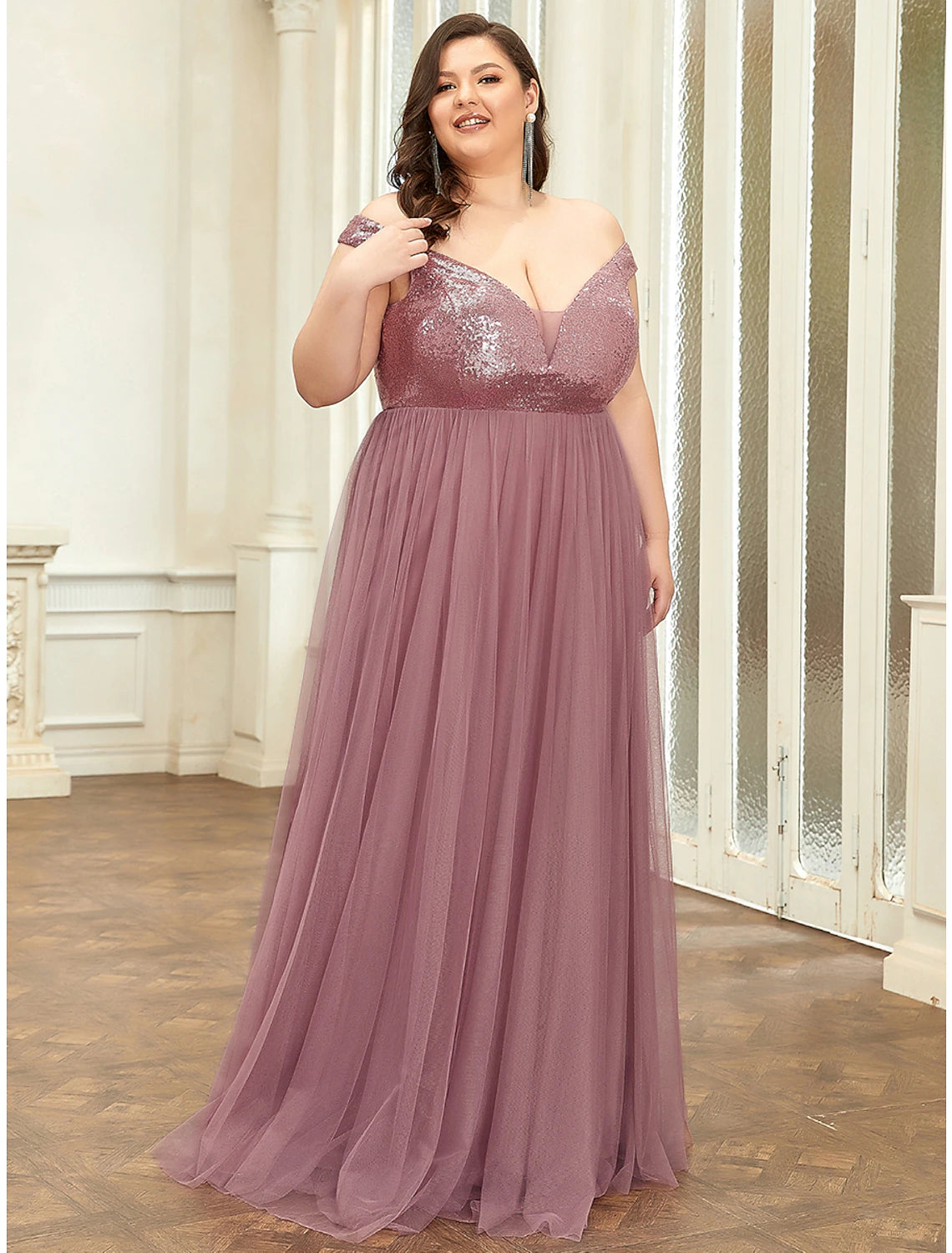 Side view of a woman in a sequined tulle bridesmaid gown with elegant draping.