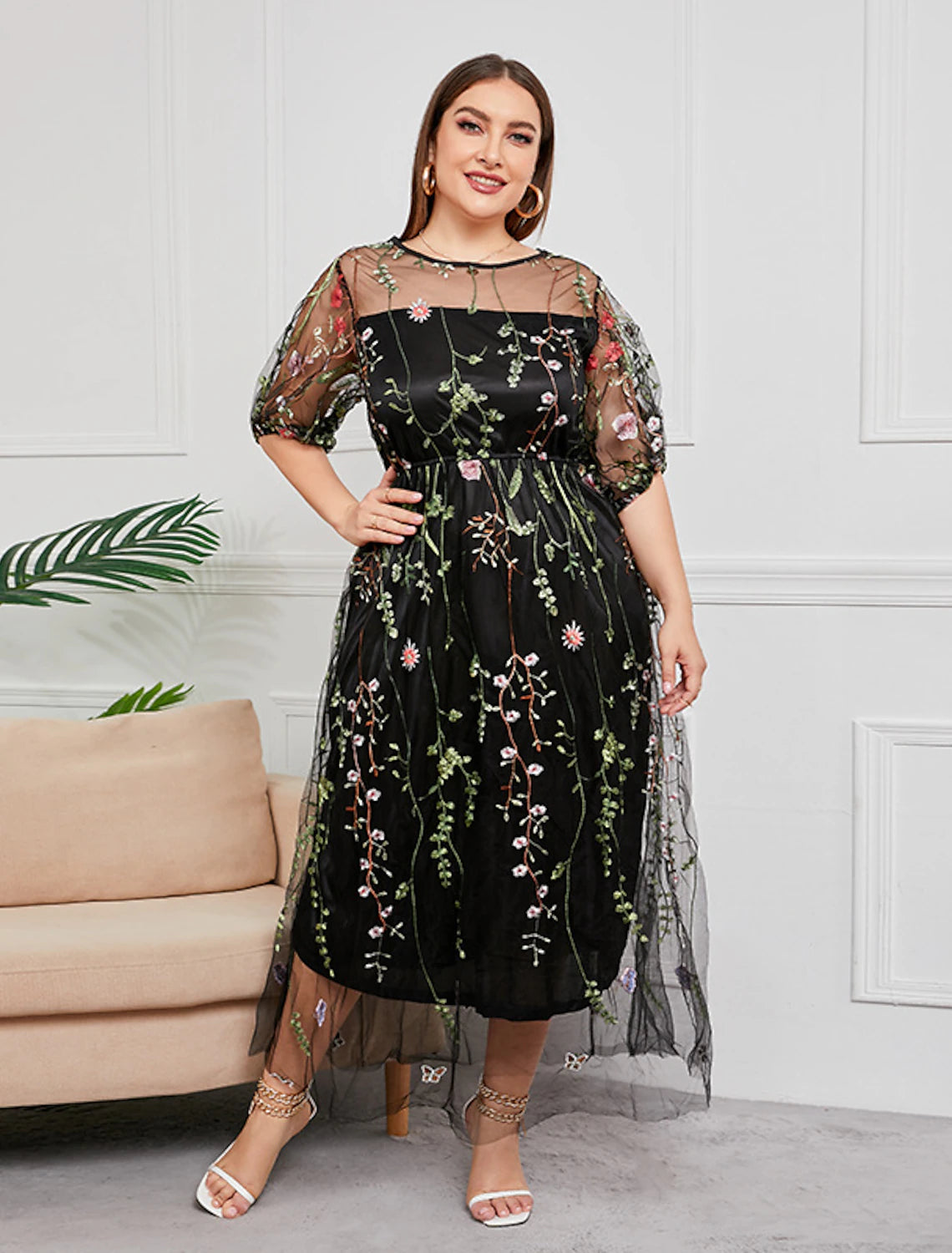 Plus size woman in a flattering scoop neck half sleeve embroidered mother of the bride gown.