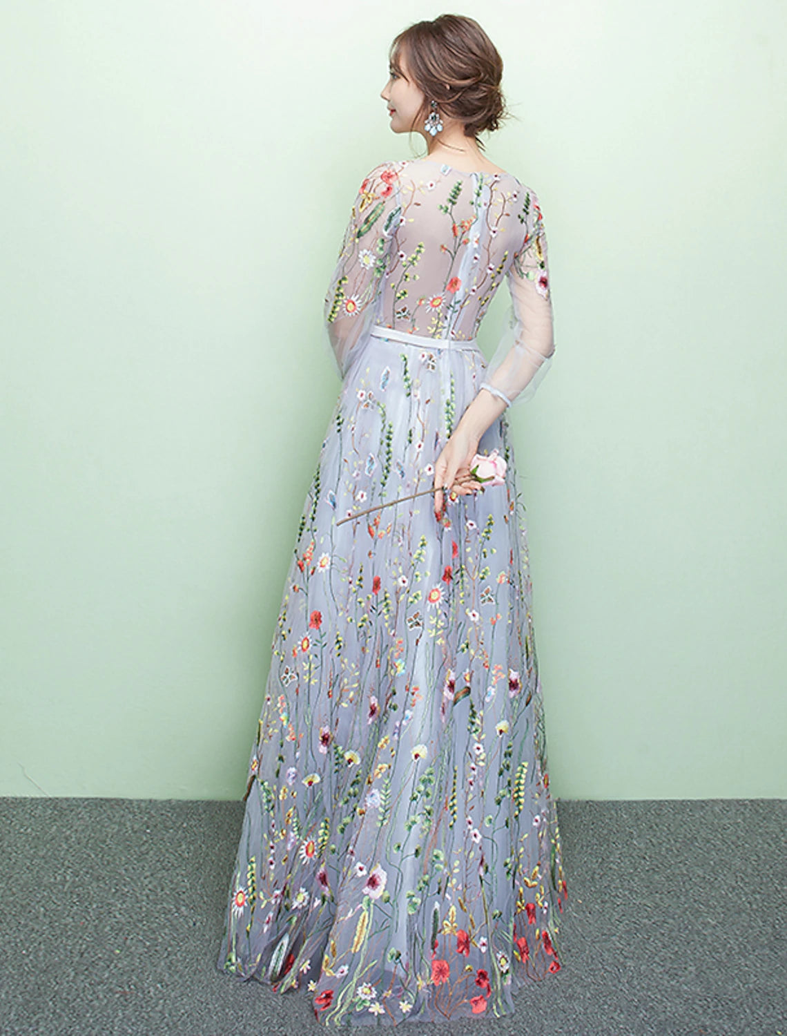 Close-up of the jewel neck and intricate lace embroidery on the formal gown.